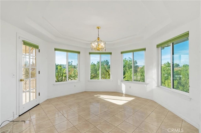 unfurnished sunroom featuring an inviting chandelier and a tray ceiling