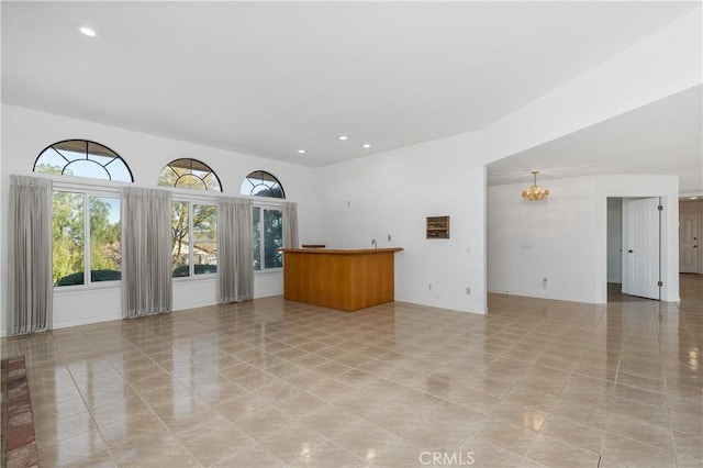 unfurnished living room with a notable chandelier