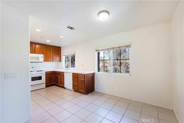 kitchen featuring light tile patterned flooring and white appliances