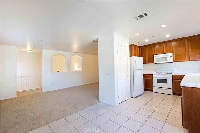 kitchen featuring light carpet and white appliances