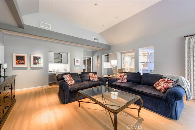 living room with vaulted ceiling and light wood-type flooring