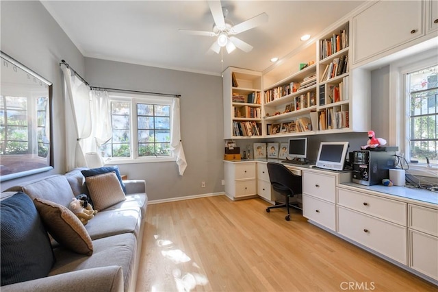 office area featuring built in desk, light hardwood / wood-style flooring, ornamental molding, and ceiling fan