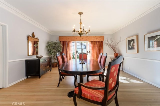 dining space with an inviting chandelier, crown molding, and light hardwood / wood-style flooring