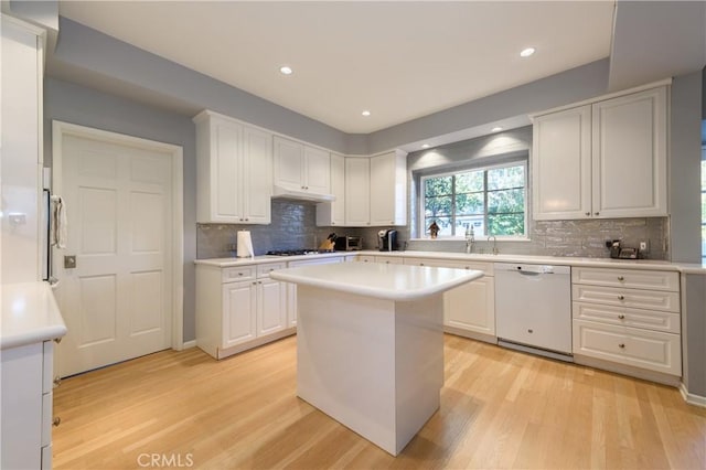 kitchen featuring white cabinetry, a center island, white dishwasher, and light hardwood / wood-style floors