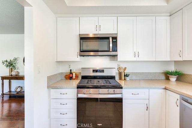 kitchen featuring white cabinetry, dark wood-type flooring, and appliances with stainless steel finishes