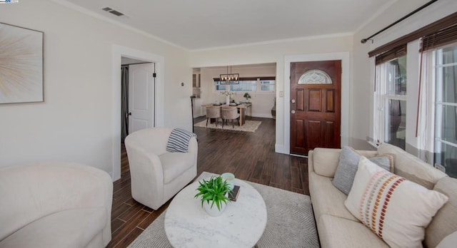 living room featuring dark hardwood / wood-style flooring, crown molding, and a healthy amount of sunlight