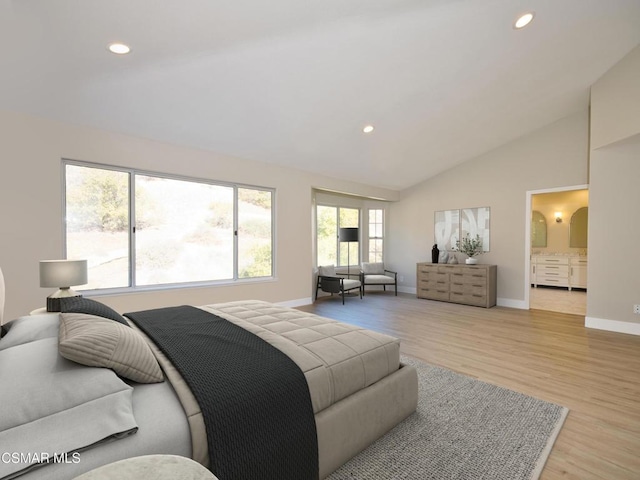 bedroom with high vaulted ceiling, light hardwood / wood-style floors, and ensuite bath