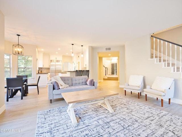 living room featuring an inviting chandelier and light hardwood / wood-style flooring