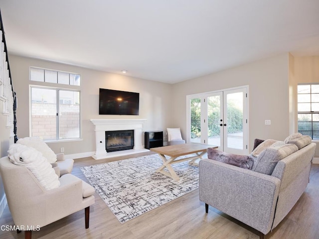 living room featuring french doors, plenty of natural light, and light hardwood / wood-style flooring