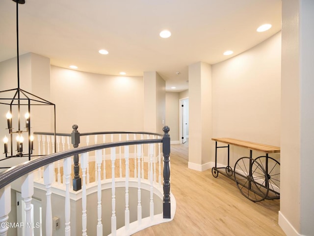 hallway with a notable chandelier and light hardwood / wood-style flooring