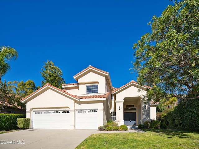 mediterranean / spanish house with a garage and a front yard