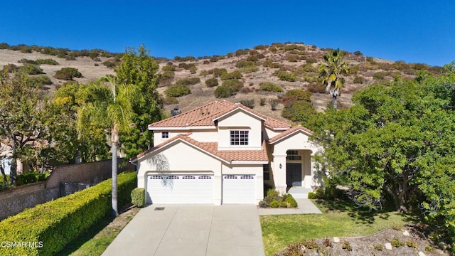 mediterranean / spanish-style home with a garage