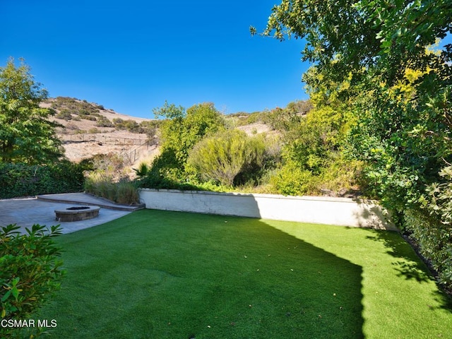 view of yard with a mountain view and a fire pit