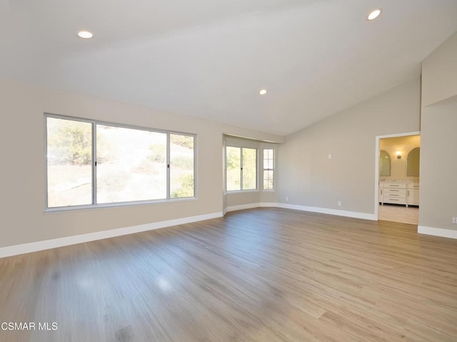 unfurnished room featuring light hardwood / wood-style flooring and high vaulted ceiling