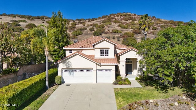 mediterranean / spanish-style house with a garage and a front yard