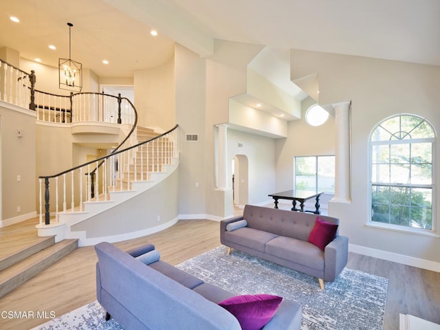 living room featuring a chandelier, high vaulted ceiling, and light hardwood / wood-style floors