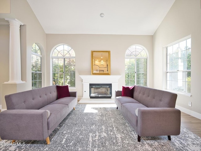 living room featuring vaulted ceiling, dark hardwood / wood-style flooring, and decorative columns