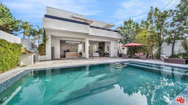 back of house featuring a balcony, an outdoor kitchen, and a patio area