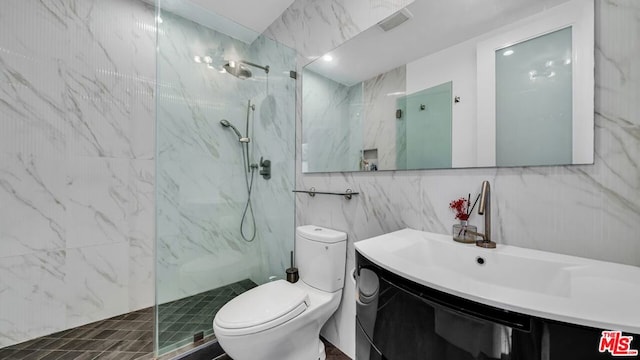 bathroom featuring vanity, tile walls, toilet, and tiled shower