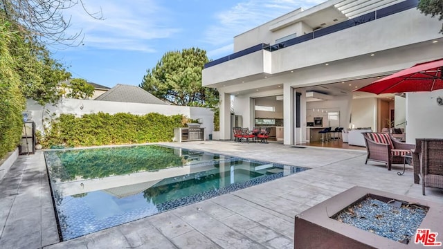 view of pool with an in ground hot tub, a patio, a wall mounted AC, and a fire pit