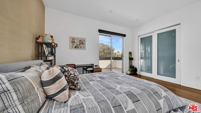 bedroom with access to exterior and hardwood / wood-style floors