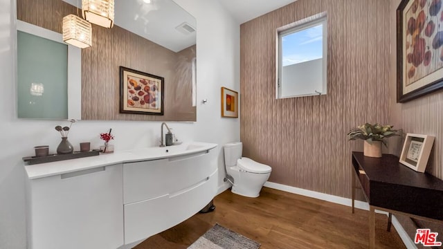 bathroom with hardwood / wood-style flooring, vanity, and toilet