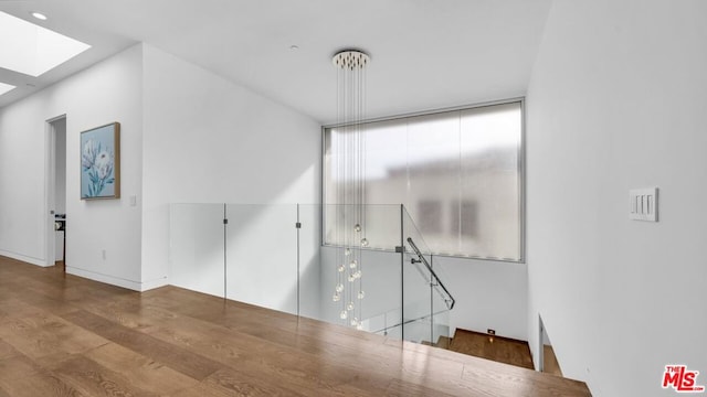 unfurnished room featuring hardwood / wood-style flooring and a skylight