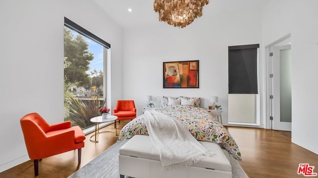 bedroom with an inviting chandelier and wood-type flooring