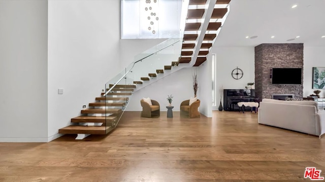 stairs with wood-type flooring and a fireplace