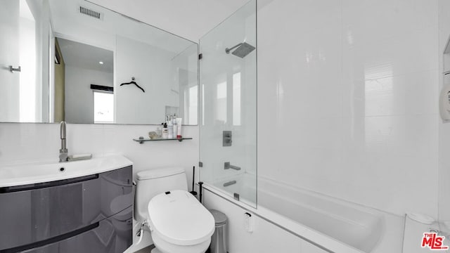 full bathroom featuring vanity, toilet, and combined bath / shower with glass door