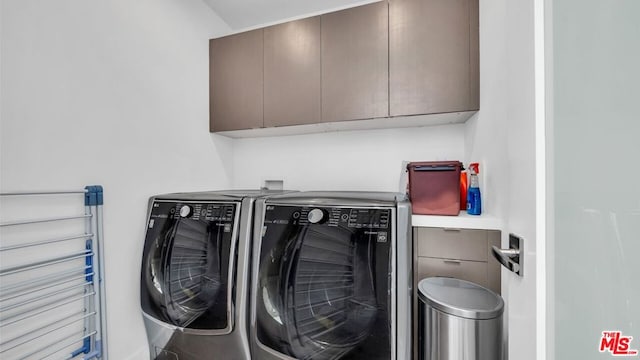 laundry room with separate washer and dryer and cabinets