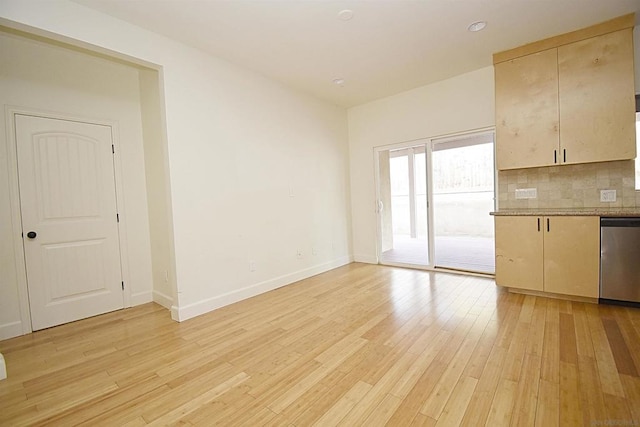 interior space featuring tasteful backsplash, dishwasher, light hardwood / wood-style floors, and cream cabinetry