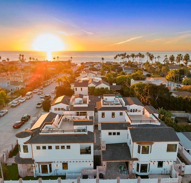 aerial view at dusk featuring a water view