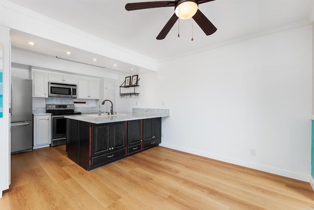 kitchen with white cabinetry, sink, kitchen peninsula, stainless steel appliances, and crown molding