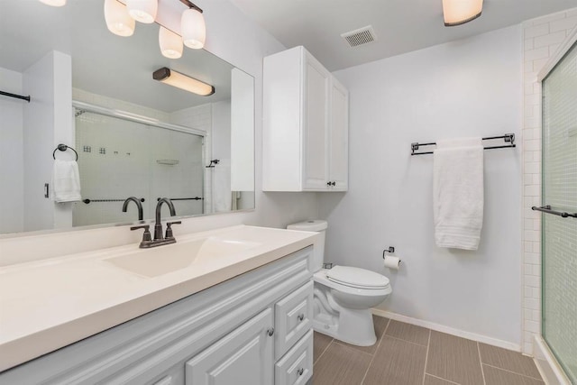 bathroom with vanity, an enclosed shower, and toilet