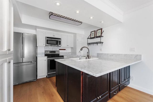 kitchen with white cabinetry, appliances with stainless steel finishes, and kitchen peninsula