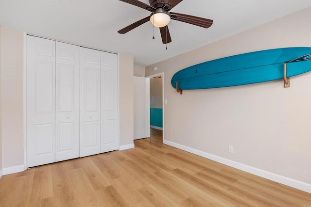 unfurnished bedroom featuring ceiling fan, a closet, and light hardwood / wood-style flooring