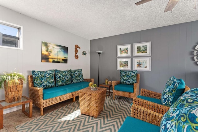 living area with ceiling fan and a textured ceiling