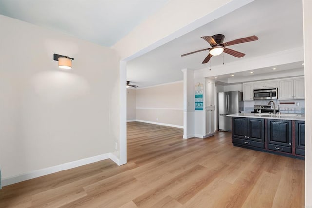 kitchen with stainless steel appliances, baseboards, light wood-style floors, light countertops, and white cabinets