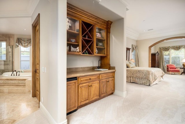 bar with light colored carpet, ornamental molding, plenty of natural light, and sink