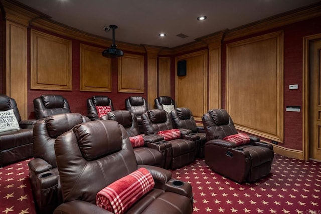 carpeted home theater featuring ornamental molding