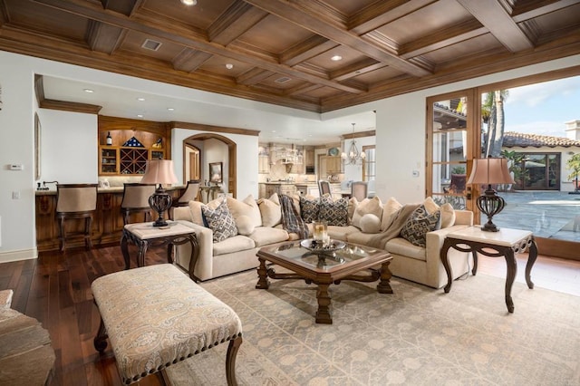 living room with an inviting chandelier, beamed ceiling, a healthy amount of sunlight, and light wood-type flooring