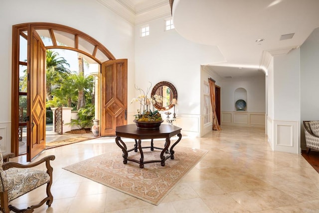 entryway featuring ornamental molding and a high ceiling