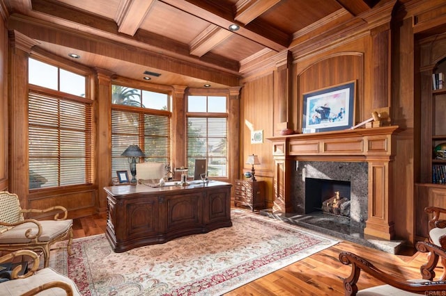 office space featuring wood walls, light wood-type flooring, coffered ceiling, wood ceiling, and beam ceiling