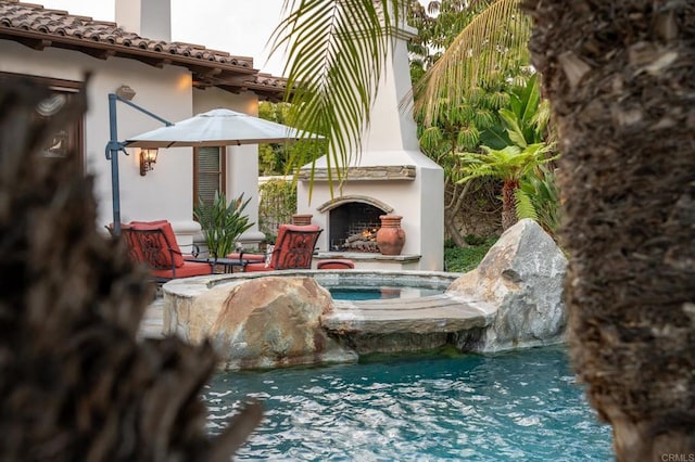 details featuring an outdoor fireplace and a swimming pool