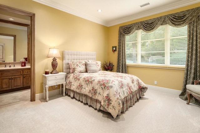 carpeted bedroom with ornamental molding, sink, and ensuite bathroom