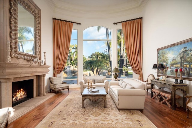 living area with a premium fireplace, crown molding, and hardwood / wood-style floors