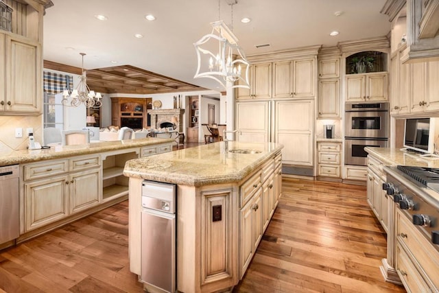 kitchen with a kitchen island, decorative light fixtures, sink, a chandelier, and stainless steel appliances