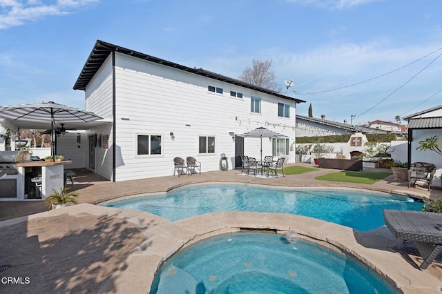 back of property with a patio, a swimming pool with hot tub, exterior kitchen, an outdoor hangout area, and ceiling fan