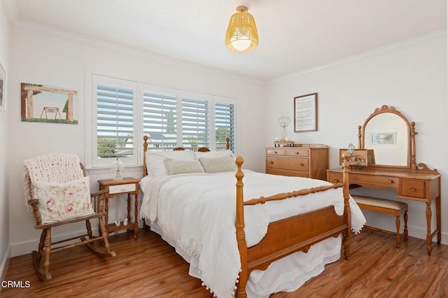 bedroom with crown molding and hardwood / wood-style flooring